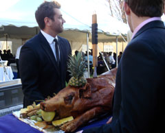 Fraternity alumni carry the pig out to guests