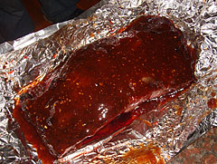 A brisket portion sauced just prior to wrapping in foil