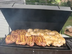 Beef brisket and chicken begin smoking on the grill